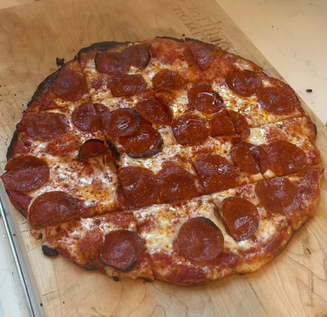 Pepperoni pizza cut on a wooden board